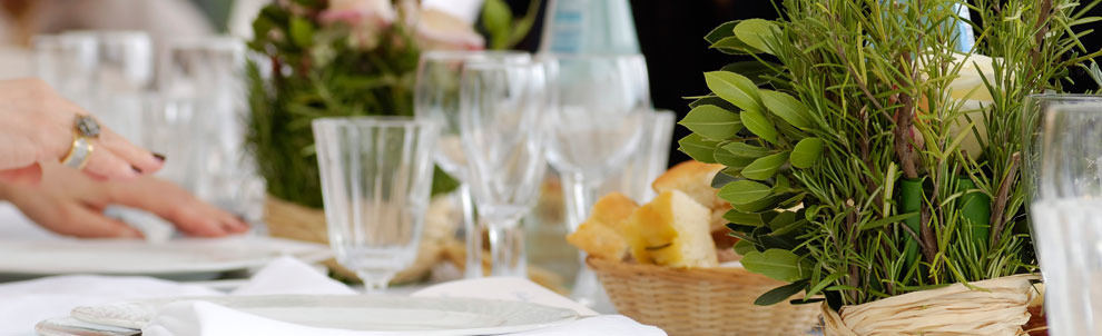 Dining table with glasses, bread, and plants on it